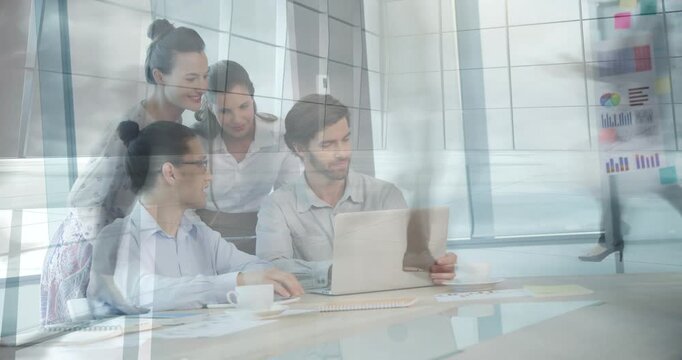 Business team leaning around laptop by glass, woman pointing, man scrolling while reviewing charts