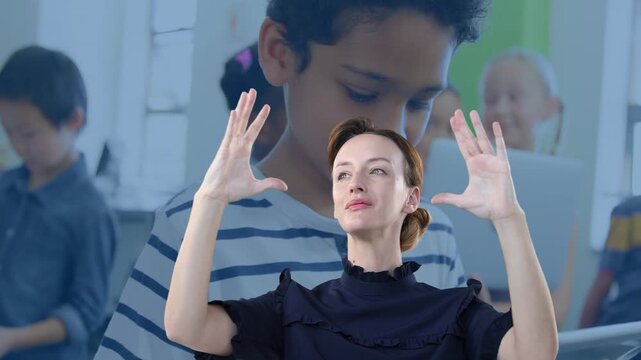 On cue presenter lifting and opening palms, tilting head, smiling engaging students on laptops