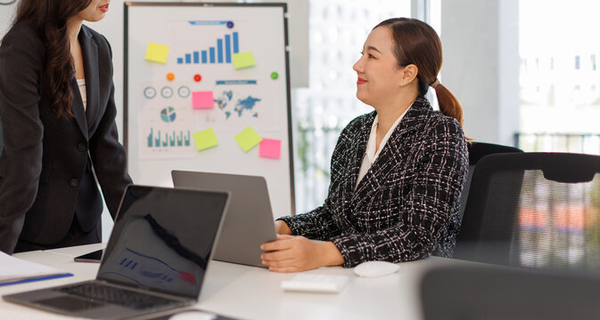 Women in business actively collaborating in a session discussing strategic marketing elements, showcasing the significance of teamwork and visual data analysis in the workplace.
