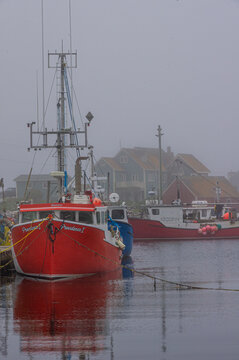 Peggy&rsquo;s Cove, Nova Scotia&mdash;June 18, 2018; The fishing boat Providence I rests in the foggy harbor with colorful village homes visible in the historic Atlantic coastal community.