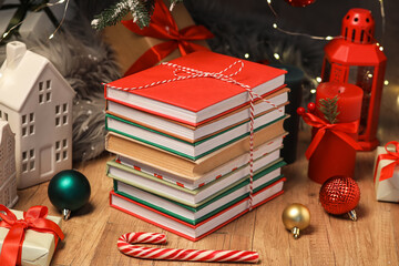 Stack of books, lantern, candle and Christmas balls on floor in living room, closeup
