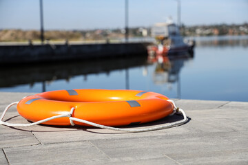 Lifebuoy ring on pier near river © Pixel-Shot