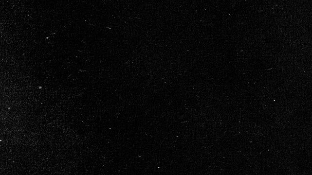 Vintage black cinematic film grain background with white dust and scratches, ideal for retro overlays and gritty video effects.