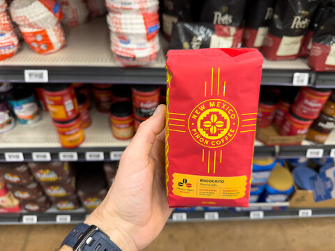 New Mexico Pi&ntilde;on Coffee Brick Package Held In Grocery Store Coffee Aisle