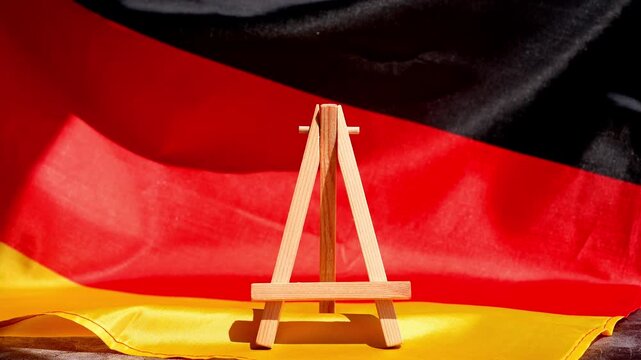 Paper note with words IMPORT on National symbol of Germany. German wave silky flag background. Concept of economy industry global market international shipping