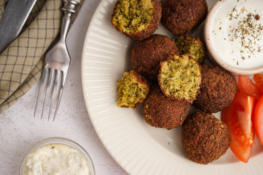 Plate with delicious falafel balls and sauce on light background, closeup