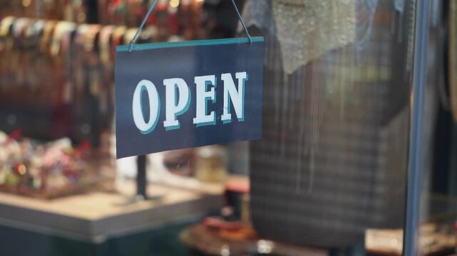 Shop displays open sign at busy location in city
