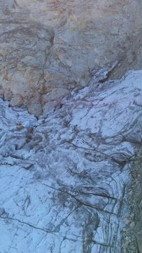 Aerial View of Icy Rock Formations and Snow Patches on a Rugged Mountain Slope in British Columbia, Canada