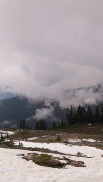 Majestic Cloud-Covered Mountains with Snow Patches in British Columbia, Canada's Serene Wilderness