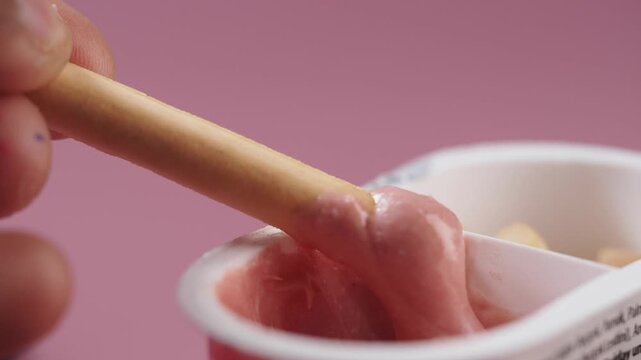 Dipping stick into creamy snack at home kitchen