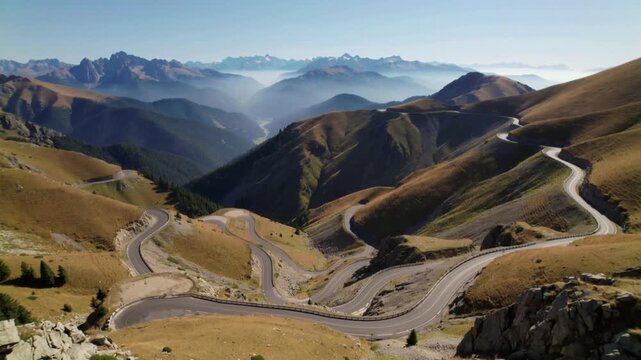 Winding mountain road with switchbacks in a vast valley landscape serpentine