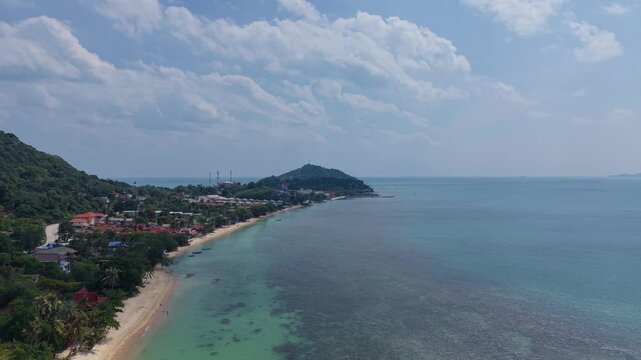 Drone footage showing the beachfront settlement and turquoise waters of Haad Rin in Koh Phangan.