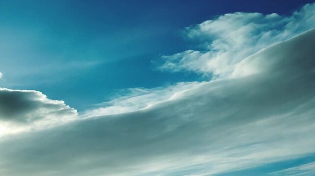Clear Blue Sky with Soft Clouds and Sunlight Above the Horizon
