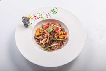 Cold donkey meat salad served on a white porcelain plate