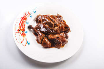 Duck with sauce served on a white porcelain plate