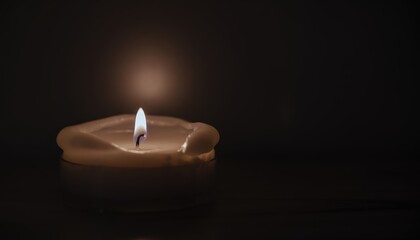 A single candle flame glows softly in the darkness representing remembrance and awareness with a gentle warmth and peaceful illumination
