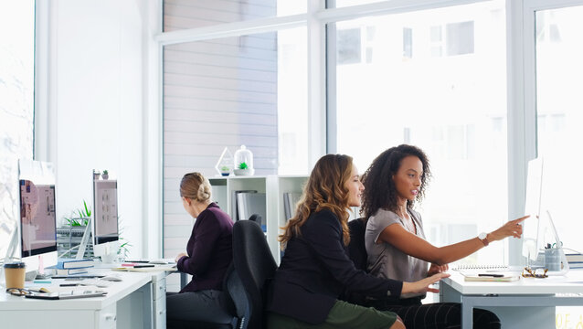 People, research and talk in office with computer, journalist teamwork or news for media publication. Creative, women and pointing in workplace with desktop, discussion and advice for online article.