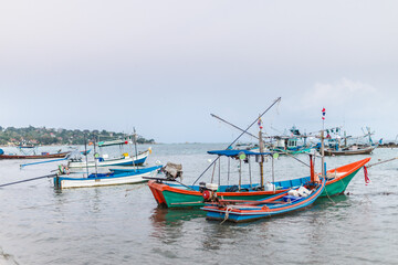 Traditional fishing boats anchored near tropical coastline in Thailand