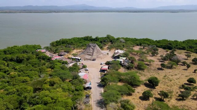 A vibrant aerial shot showcasing Totumo Volcano, surrounded by lush green trees and an expansive water body.