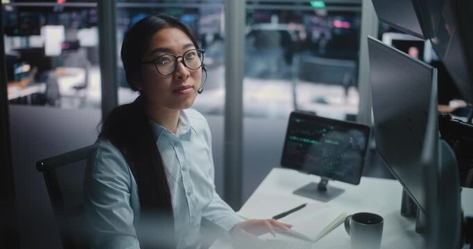 Asian Lady Broker Momentarily Steps Away From Analyzing Complex Charts Chat With Loved One on Smartphone. Positive Emotions and Refreshing Break in Futuristic Office, Human Side of Corporate Career.