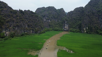 Traditional Vietnamese rowing boats with local rowers on the scenic river of UNESCO site Trang An © GeoWild