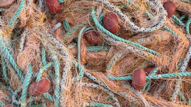 Fishing nets intertwined with ropes and floats create a textured, colorful background