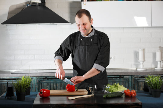 Man cook preparing food at the kitchen of vegetables