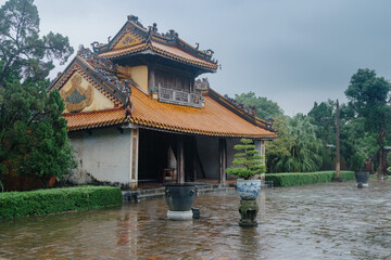 Naklejka premium Tourists visit the TMausoleum of Emperor Tu Duc, Hue, Vietnam, to learn about the history of the Nguyen Dynasty on a rainy day in Vietnam.