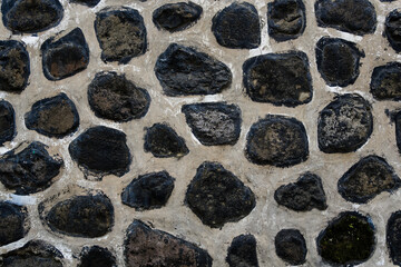 Fototapeta premium Rustic natural stone wall with traditional mortar pattern. Textured masonry background for architecture, home decor, and heritage themes.