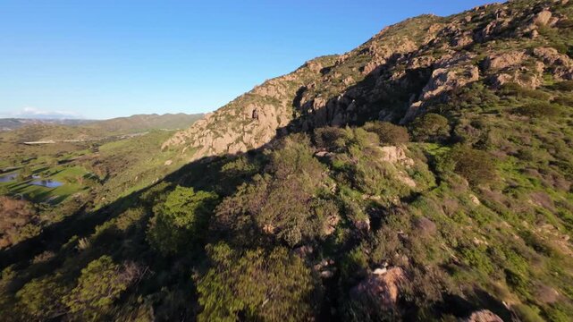 Conejo Mountain's rugged terrain in Ventura County on a clear day in California. low altitude, first person aerial flyover
