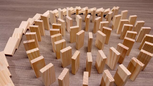 Butterfly effect, wooden circle dominoes falling over in motion probability future chance, a powerful metaphor for potential energy, each fall opening possibilities, imminent circular chain reaction