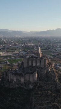 Vertical aerial drone circling Castle of Monteagudo and surrounding scenic landscape.