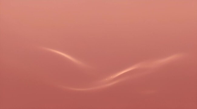 Abstract salmon colored background with a soft blurry light formation