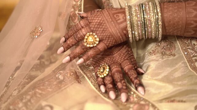 Close-up of Indian Bride Showing Hands with Intricate Mehendi (Henna) and Gold Jewelry