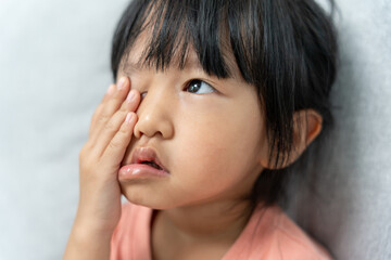 Eye problems, Asian child use hand cover eyes due to eye irritation, eye rubbing, dry, eye pain after look VDO Game long time, migraine, dirty hand touch eye, blurred vision, photophobia