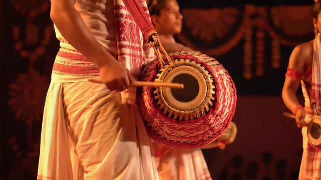 Traditional Assamese dancer playing dhol drum for bihu festival
