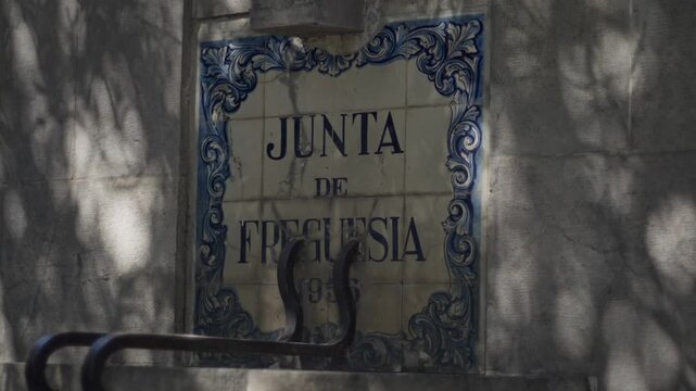 Ceramic tile sign reading Junta de Freguesia on building wall Portugal