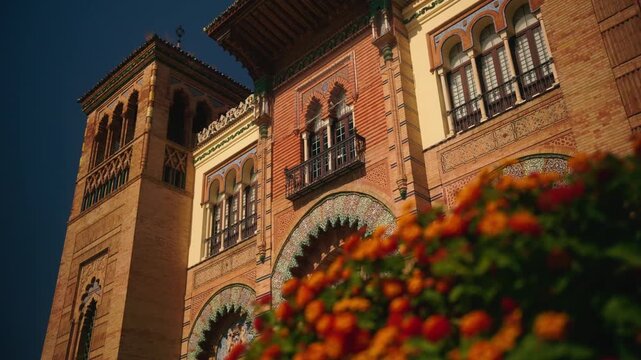 Historic building facade with arches and colorful flowers