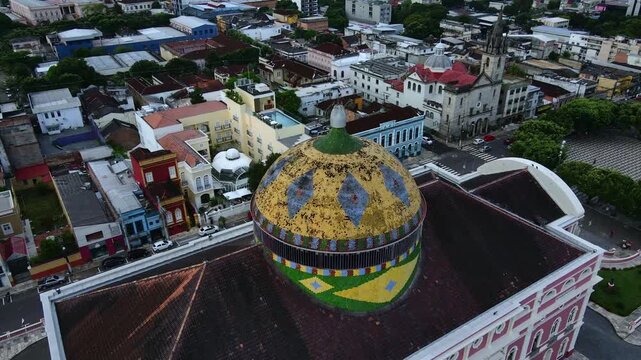 Ornate roof and dome of Teatro Amazonas at Largo de S&atilde;o Sebasti&atilde;o during a cloudy afternoon. Manaus, Brazil. Aerial orbit circling roof in 4K.