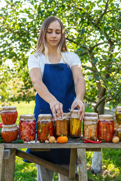woman canning tomatoes cucumbers vegetables on the background of nature. Selective focus