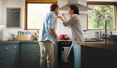Obraz premium Cooking, taste and happy couple with food in kitchen for dinner, supper and meal prep. Marriage, home and man with woman by stove for recipe, ingredients and cuisine for bonding, help and love