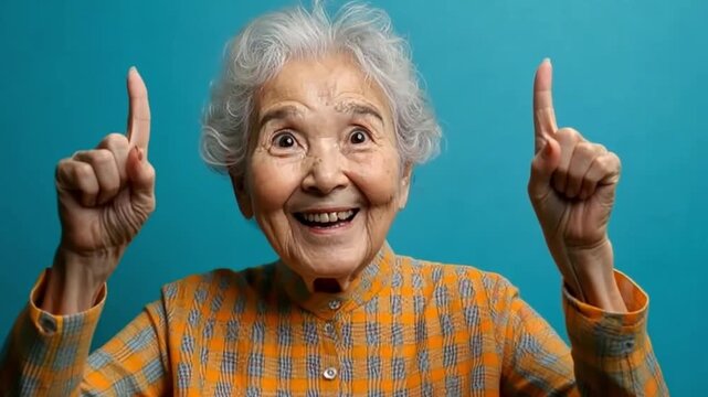 Older woman smiling and pointing fingers up in a colorful setting during daytime