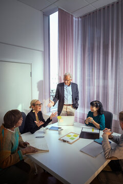 Group of senior entrepreneurs discussing in office team meeting