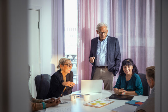 Group of senior management discussing business ideas in meeting at office