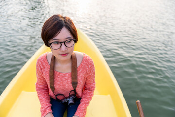 Woman sitting yellow boat water
