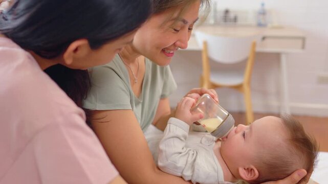 Asian lesbian couple caring for and raising their baby boy at home.