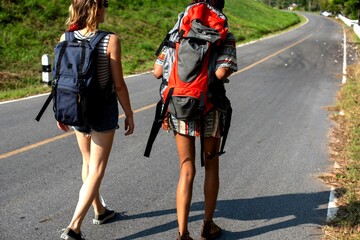 Fototapeta premium Backpackers exploring scenic road.