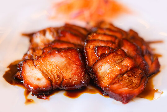 Closeup slices of glistening Char Siu, a classic Cantonese barbecue pork dish.