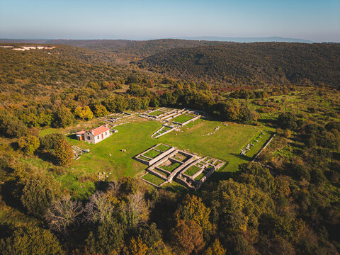 Aerial view of the ancient Roman ruins stand in stark contrast to the surrounding green meadow and lush forest, creating a tapestry of history and nature, Sisan, Istria County, Croatia.