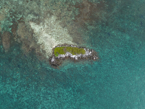 Aerial view of Camar Rock Island, a tiny island surrounded by turquoise water, Jepara Regency, Indonesia.